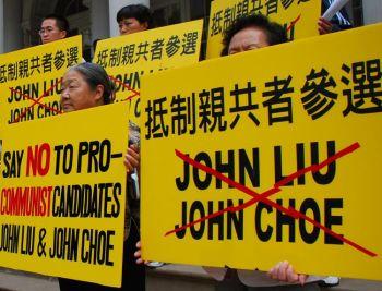Demonstranter håller iögonfallande skyltar som fördömer John Liu, kandidat till stadsrevisionschef. (Foto: Helena Zhu / The Epoch Times)
