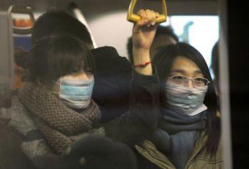 Två kvinnor med ansiktsskydd på tunnelbanan i Peking, 2 december 2009. Serum eller plasma från människor som tillfrisknat från H1N1-influensan används för att behandla patienter i Kina som är allvarligt sjuka på grund av viruset. (Foto: Peter Parks/AFP/Getty Images)