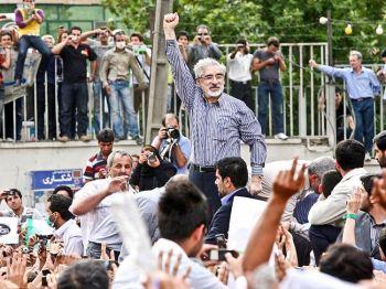 Besegrad reformorienterad presidentkandidat Mir Hossein Mousavi (mitten) höjer armarna när han visar sig under en demonstration på gatorna den 15 juni 2009 i Teheran, Iran. (Foto: Getty Images)