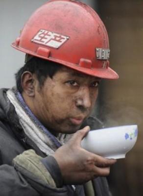 En gruvarbetare dricker soppa efter ett 12-timmarsskift där man försökt rädda medarbetare vid Wangjialings kolgruva. (Foto: Getty Images)
