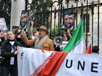 Iranske fotografen Reza (i mitten med hatt) och väktarna av mediernas rättigheter, Reportrar utan gränser (RSF), håller upp ett skrynklat porträtt av Irans president Mahmoud Ahmadinejad under en protestdemonstration framför den iranska ambassaden i Paris, den 3 maj 2010, med krav på frigivning av journalister som sitter fängslade i Iran. (Foto: Miguel Medina / AFP / Getty Images)
