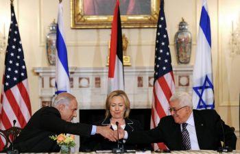 USA:s utrikesminister Hillary Clinton ser på när Israels premiärminister Benjamin Netanyauhu (t.v.) och Palestinas president Mahmoud Abbas skakar hand på utrikesdepartementet i Washington DC den 2 september. (Foto: Jewel Samad/Getty Images)
