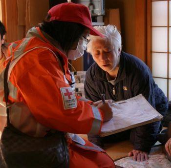 Personal från det japanska Röda Korset ger stöd till drabbade personer i ett centrum för evakuerade den 19 mars 2011. Den psykiska hälsan hos dem som drabbades hårt av jordbävningen och tsunamin är ett stort bekymmer. (Foto: Japanska Röda korset / IFRC genom Getty Images)
