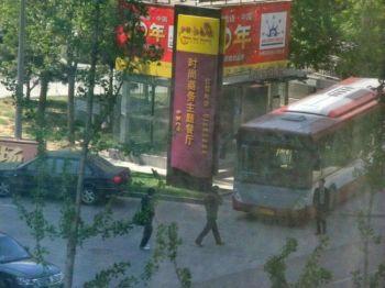 Polisbilar och bussar står parkerade nära Shouwangkyrkans gudstjänstplats i Peking och väntar på att föra bort kyrkomedlemmar, den 24 april. (Fotot taget av en anonym kyrkomedlem)