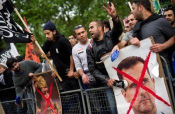 Demonstranter slog med skor på en affisch av Syriens president Bashar al-Assad under en demonstration utanför den syriska ambassaden i London den 7 maj 2011. (Foto: Leon Neal/ AFP/Getty Images)
