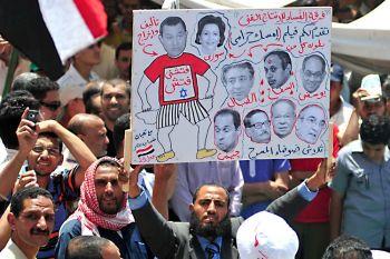 Egyptiska demonstranter skyltar med bilder på Hosni Mubarak, hans fru och medlemmar i hans regim, under en demonstration den 8 juli. (Foto: AFP/Getty Images)
