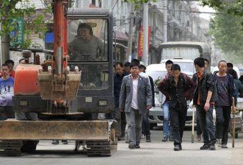 Kinesiska myndigheter bär påkar samtidigt som de förbereder sig för att vakta när arbetare river hus. Detta sägs vara olagligt, enligt lokala myndigheter i Wuhan, Hubeiprovinsen den 7 maj 2010. Markkonfiskering är, sedan flera år tillbaka, ett problem i Kina, och tvångsvräkningar är vanligt förekommande. (AFP/Getty Images) 