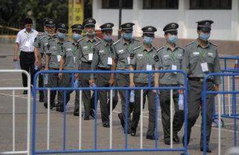 En grupp kinesiska säkerhetsvakter med munskydd utanför Yan Xiang-hotellet i Peking, 21 juli i år. (Liu Jin/AFP/Getty Images)