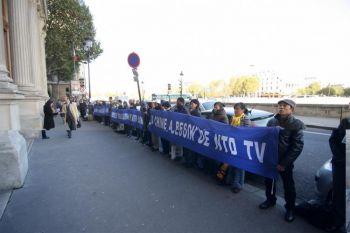 New Tang Dynasty Televisions (NTDTV:s) supportrar håller banderoller utanför Paris Commerce Court för att stödja återställandet av NTDTV:s sändningar till Kina. (Foto: Ye Xiaobin/The Epoch Times)
