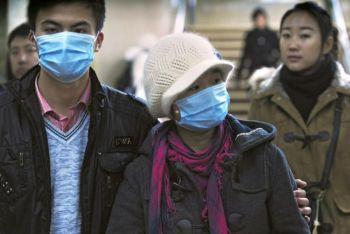 Ett par som bär ansiktsmasker i Pekings tunnelbana, 2 december 2009. Kinas dödstal i H1N1 kan vara hundratusentals enligt en medicinsk expert.(Peter Parks/AFP/Getty Images)