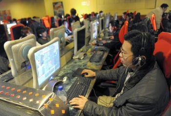 En ung man som spelar onlinespel på ett internetcafé i Peking. De kinesiska sökmotorerna Baidu och Sogou har plötsligt slutat filtrera information om internationella rättsprocesser mot förre kinesiske regimledaren Jiang Zemin. (Foto: Liu Jin/AFP/Getty Images)