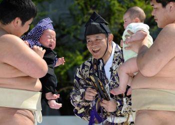 En kimonoklädd domare tittar på när två barn, som hålls av sumobrottarelever, börjar gråta under "Sumo-bäbisgråt"-tävlingen vid Sensoji-templet i Tokyo den 25 april. (Foto: Toru Yamanaka / Getty Images)