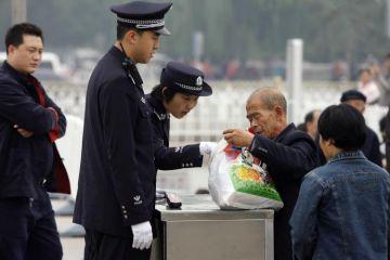 Polis genomsöker en mans väska på Himmelska Fridens torg inför det Kinesiska Kommunistpartiets Nationella kongress i oktober 2007. Intensiva säkerhetsåtgärder pågår redan inför nästa månads Peking-OS. (Foto: Peter Parks/Getty Images) 