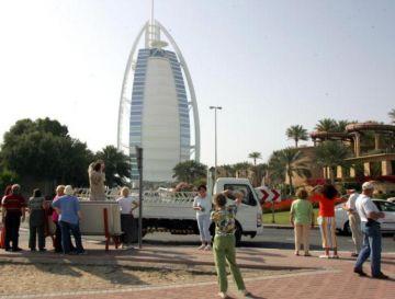 Europeiska turister tar bilder av Burj al-Arab (till vänster) och Jumeirah Beach Hotel i Dubai. (Foto: Rabih Moghrabi)