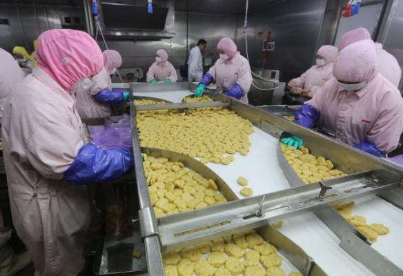 Arbetare vid Husi Food i Shanghai, 20 juli 2014. Myndigheter i Shanghai har stängt fabriken efter att det framkommit att man använt otjänligt kött i snabbmatsprodukter. (Foto: STR/AFP/Getty Images)