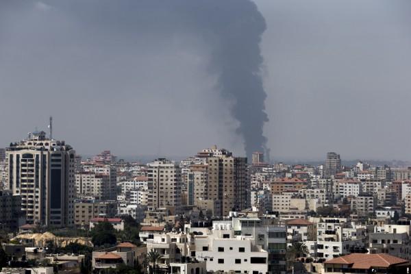 Kraftverket Nuseirat brinner i bakgrunden i Gaza den 29 juli 2014. Det är det enda kraftverket Gazaremsan får elektricitet ifrån, sade energiansvarig i Palestina idag. (Foto: Marco Longari / AFP/ Getty Images)