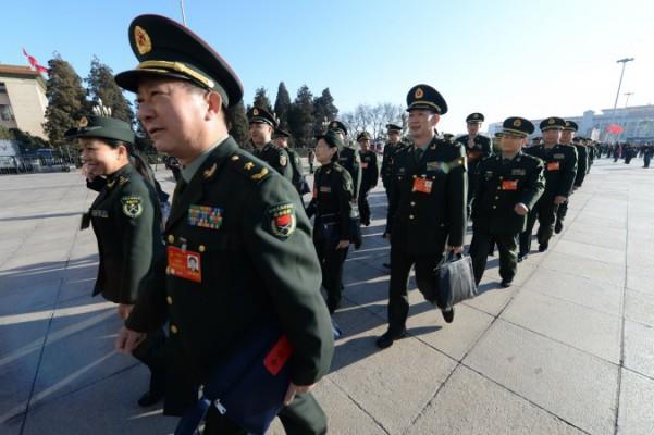 Militärdelegater anländer för avslutningsceremonin under den Nationella folkkongressens möte vid Folkets stora sal i Peking den 13 mars. Partiledaren Xi Jinping har tillsatt sig själv som chef för ett nytt utskott för militärreformer. (Foto: Goh Chai Hin/AFP/Getty Images)
