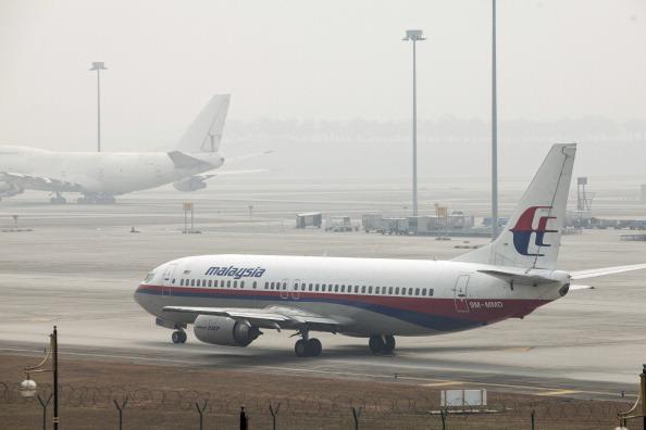 En Boeing 737 flygplan som drivs av Malaysian Airline System Bhd (MAS) syns genom dimman på Kuala Lumpur International Airport (KLIA) i Sepang, Malaysia, fredagen den ​​14 mars, 2014. Indiska styrkor utökade sökandet efter det försvunna Malaysian Airlines Flight 370 med 239 personer ombord, till Bengaliska viken, efter att det kommit fram bevis på att planet kan ha flugit långt efter det att flygledare förlorat kontakten med det för en vecka sedan. (Foto: Charles Pertwee /Bloomberg via Getty Images)