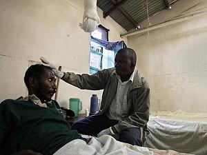 Charles Kibe (t.h.) är volontär och arbetar med hiv/aids-infekterade personer i slumområdet Korogocho i östra Nairobi. Här tar han hand om en patient i en hälsoklinik som drivs av den katolska kyrkan. (Foto: Simon Maina/AFP/Getty Images)
