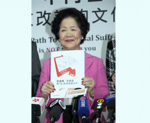 Vid en presskonferens den 6 januari 2014 håller Anson Chan upp ett plakat där vägen till allmän rösträtt går runt den labyrint som regeringens förslag liknas vid. (Foto: Epoch Times)

