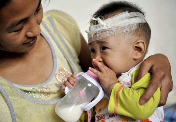 En kinesisk mamma tar hand om sitt barn som lagts in på sjukhuset i Wuhan, Hubeiprovinsen i centrala Kina, den 13 september. Minst ett barn har dött efter att ha druckit mjölk innehållande melamin. (Foto: AFP/ Getty Images) 