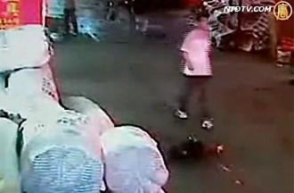 En man går runt Yue Yue strax efter att hon blivit överkörd av en minibuss. (Skärmdump från NTD Television)
