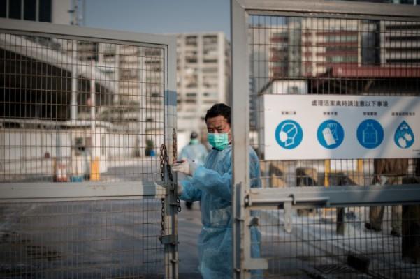 En säkerhetsvakt stänger porten till en fjärderfämarknad i Hongkong, den 28 januari i år. Ett nytt utbrott av fågelinfluensa i Kina har inträffat, där en ny variant på viruset har dykt upp. (Foto: Philippe Lopez/AFP/Getty Images)
