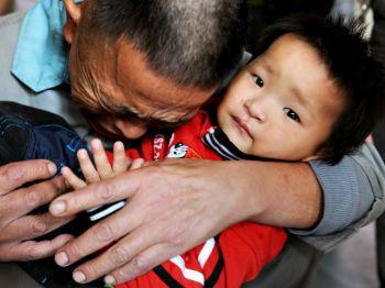 Wang Bangyin kramar sin son, som var ett av 60 barn som räddades från människohandlare i Guiyang i sydvästra Kina den 29 oktober i år. (STR/AFP/Getty Images)