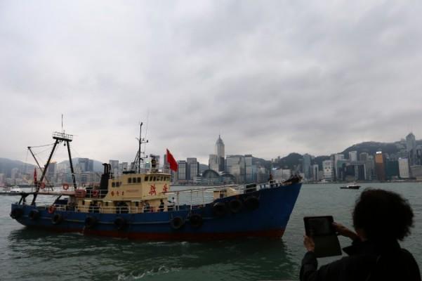 En kinesisk fiskebåt, som varit iland på en av Japans Senkaku-öar, seglar in mot Victoria-hamnen i Hongkong den 13 november 2013. Kina är nu på väg att göra sin fiskeflotta till en del av militären. (Aaron Tam/AFP/Getty Images)