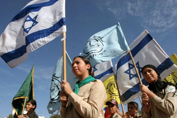 ISRAEL, RAHAT : Beduinska barn bär den Israeliska flaggan under en parad efter att premiärminister Ehud Olmert invigt en beduinsk skola i staden Rahat i södra Israel den 26 November 2006. Olmert sade att Israel skulle visa "återhållsamhet och tålamod" vid bemötandet av det Palestinska militanta våldet i Gaza remsan. AFP PHOTO/LIMOR EDREY-ISRAEL OUT 