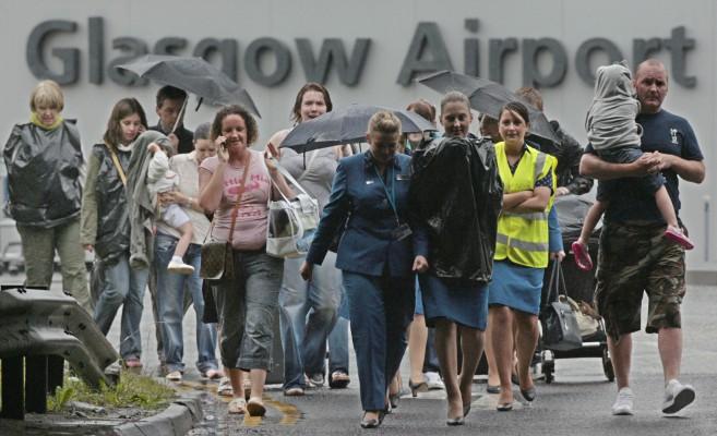 Personal och passagerare flyr Glasgow flyplats efter bilattacken i lördags. Storbritanninen har infört högsta säkerthetsläge efter helgens hotfulla händelser i London och Glasgow. (AFP/KIERAN DODDS) 