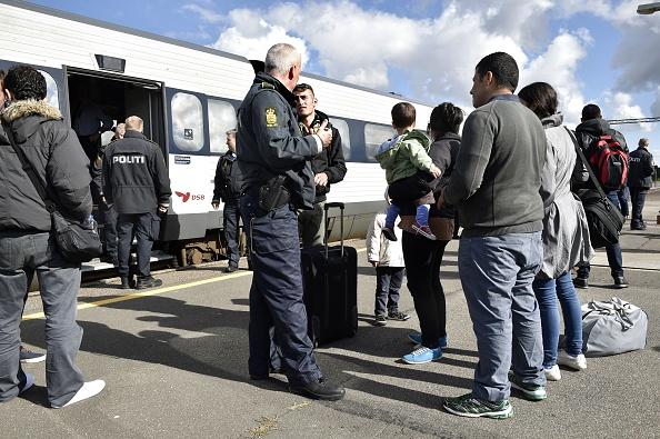 Några flyktingar talar med dansk polis men många flyktingar vägrar kliva av tågen i Danmark i tron att det är bättre att fortsätta till Sverige. Foto: Bax Lindhardt /AFP/Getty Images