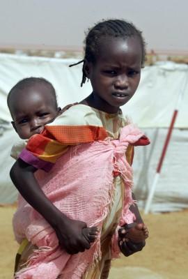 Flyktingbarn går förbi tälten i Abu Shouk lägret nära Al-Fasher, huvudstaden i den krigshärjade norra Darfurområdet i Sudan. Mer än 50,000 flyktingar bor i lägret, som grundades i april 2004 och är det största lägret i provinsen. (Foto: AFP/Ramzi Haidar)
