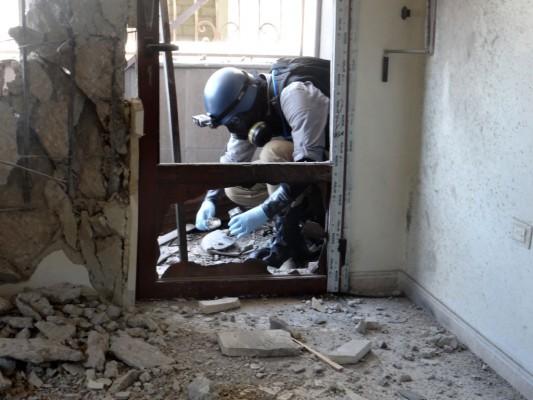 En vapenexpert hos FN samlar in material den 29 augusti 2013 när de kontrollerar platsen för raketattacken i Ghoutaområdet i Damaskus. (Foto: AFP/Ammar Al-Arbini)