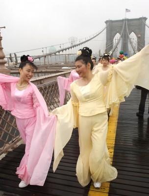En ny amerikansk studie visar att det kan löna sig att vara positiv - lycka kan ge ett skydd mot hjärtsjukdomar. Redan de gamla kineserna visste att det var viktigt att må bra i själen för att bibehålla sin fysiska hälsa. På bilden ser vi två glada Falun Gong-utövare som visar upp traditionell kinesisk dans under en parad i New York.  Den uråldriga qigongmetoden Falun Gong är välgörande för både kropp och själ och har fått många utmärkelser för sina mycket goda hälsoeffekter.(Foto:AFP /Stan HONDA) 
