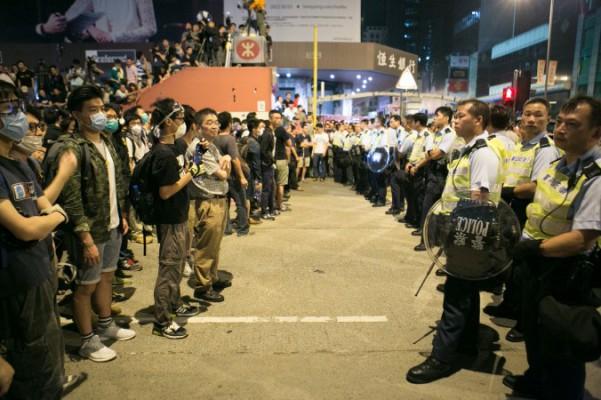 Dödläge mellan prodemokratiska demonstranter och polisen efter att polisen hela natten försökt stänga av delar av Argyle Street och Nathan Road i Mongkok, Hongkong, den 18 oktober 2014. (Foto: Benjamin Chasteen/Epoch Times) 