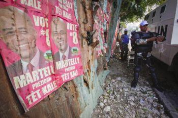 Indiska FN-trupper med skyddsutrustning bredvid affischer av presidentkandidat Michel "Sweet Micky" Martelly i närheten av den tillfälliga valbyrån i Petionville, Haiti. den 4 april  2011  (Foto:Lee Celano/Getty Images) 
