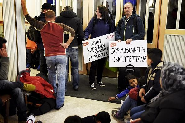 Irakiska flyktingar väntar på tåget tillsammans med personer som ska delta i fredagens protester i Helsingfors, på Kemi tågstation i nordvästra Finland, den 17 september 2015. Protesterna väntas dra till sig tiotusentals människor. (Foto: Jussi Nukari/ AFP/ Getty Images)