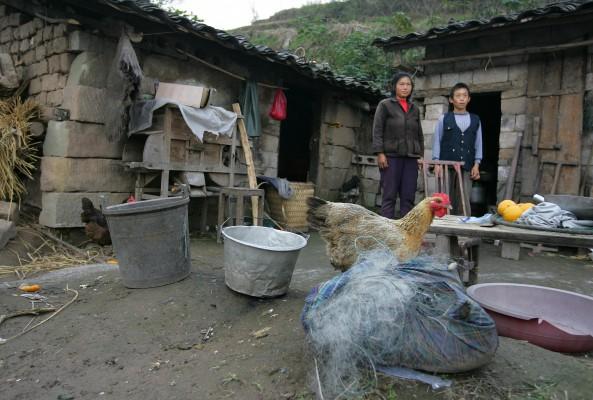 Fu Xiuqiong och hennes man Jiang Yongchang bor i ett provisoriskt skjul, efter att lokala tjänstemän jämnat deras hem med marken för att bereda plats för de höjda vattennivåerna i vattenreservoaren vid De tre ravinerna i Kina. (Frederic J. Brown/AFP/Getty Images)
