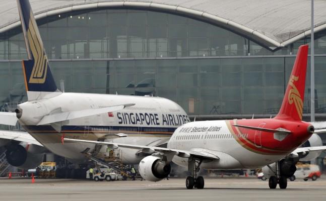 Ett kinesisk flygplan Shenzhen Airlines Airbus (höger) rullar förbi Singapore Airlines flygplan på Hong Kong internationella flygplats. Över tusen kinesiska tjänstemän lämnade nyligen landet, enligt färska rapporter. (Foto: Laurent Fievet/AFP)
