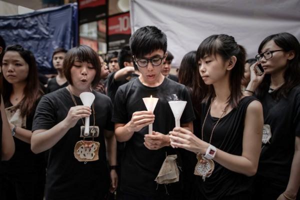 Studenter blåser ut ljus efter att ha sjungit en sång till minne av massakern på Himmelska fridens torg den 4 juni på gatan som leder till en minnesvaka i Hongkong den 4 juni. (Foto: Philippe Lopez/AFP)
