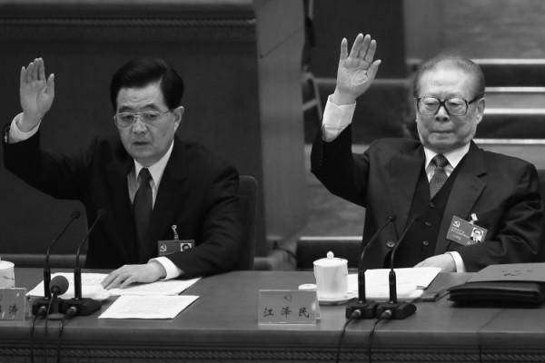 Den avgående ordföranden för det kinesiska kommunistpartiet Hu Jintao (till vänster) och före detta partichefen Jiang Zemin räcker upp handen under den avslutande delen av den 18:e partikongressen den 14 november 2012 i Peking. Hu Jintaos efterföljare Xi Jingping tillkännagavs vid kongressen. (Foto: Feng Li/Getty Images)
