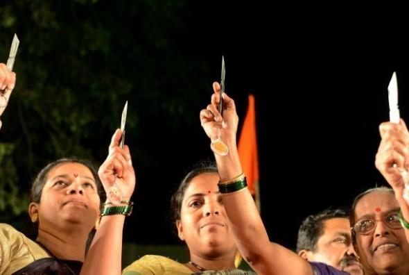 Indiska kvinnor håller upp knivar under en tillställning som anordnades av det hinduiska nationalistiska Shiv Senapartiet i Mumbai den 23 januari 2013. (Foto: Punit Paranjpe/AFP/Getty Images)