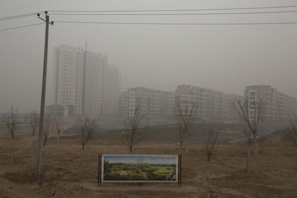 På bilden visas en reklamskylt för ett bostadsprojekt en dag med väldigt mycket luftföroreningar i Shijuazhuang i Hebeiprovinsen i norra Kina. Att besegra föroreningarna har hamnat högt på agendan för det styrande kommunistpartiet, som i åratal har drivit den ekonomiska utvecklingen utan någon hänsyn till påverkan på miljön. Efter påtryckningar från allmänheten om att minska de luftföroreningar som ligger som täcken över Peking och andra städer runt om i Kina har landets ledare lagt om sina prioriteringar. (Foto: AP Photo/Alexander F. Yuan)