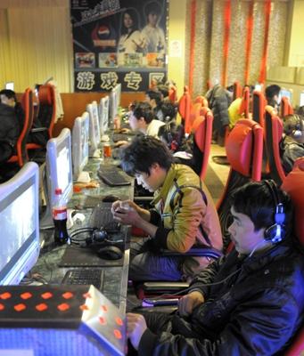 Unga män spelar internetspel på ett internetcafé i Peking i februari 2010. Med blicken klistrad till skärmen och hörlurar i öronen blir man avskärmad från den yttre världen. Internetcaféer används mer och mer i Kina. (Foto: AFP/Liu Jin)
