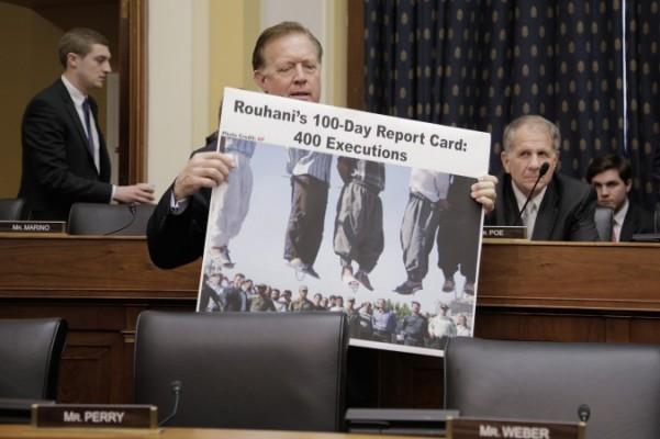 Randy Weber, medlem i USA:s representanthus, håller upp en affisch som anklagar Irans president Hassan Rouhani för hundratals avrättningar. (Foto: T.J. Kirkpatrick/Getty Images)
