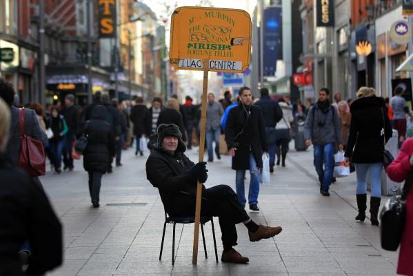Arkivbild från den 25 november 2011 på en man som håller en skylt med texten “Irländsk spåkvinna/-man på O’Connel Street i Dublin. (Peter Muhly/AFP/Getty Images)