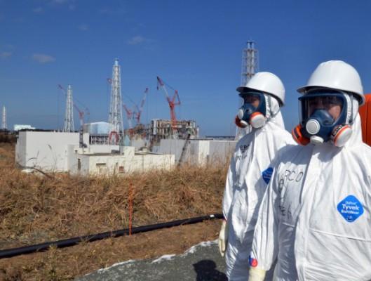 Arbetare står nära det havererade kärnkraftverket Daiichi i Fukushima i slutet av februari. (Foto: Yoshikazu Tsuno /AFP/Getty Images)
