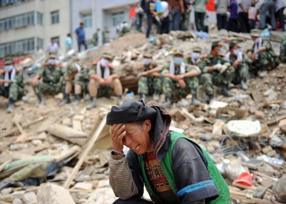 En kinesisk kvinna gråter bland spillrorna medan räddningsarbetarna tar en paus efter den massiva jordskred i Zhouqu, nordvästra Kina i Gansu-provinsen den 11 augusti. Häftiga regn har förvärrat eländet i den kinesiska staden som drabbades av jordskred. Nya översvämningar hindrar hjälpinsatserna och stanken av död är genomträngande. (Foto: AFP)