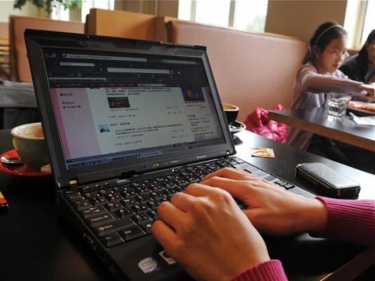 En kvinna kollar Sina Weibo, Kinas motsvarighet till Twitter, på ett kafé. (Mark Ralston/AFP/Getty Images)